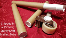 Load image into Gallery viewer, Cardboard mailing tubes and a shipping tape dispenser on a red surface.